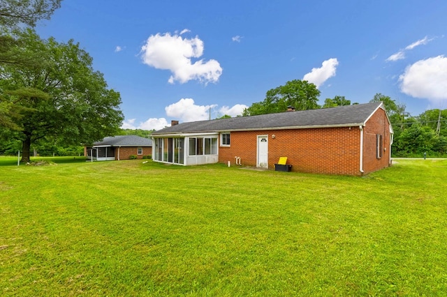 1508 W Hanley Rd, Mansfield, OH 44904 - rear view of house with a sunroom, brick siding, a yard, and a chimney