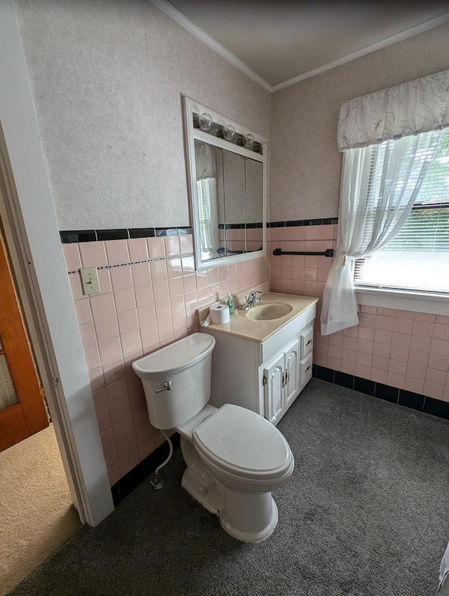 bathroom with crown molding, vanity, tile walls, and toilet