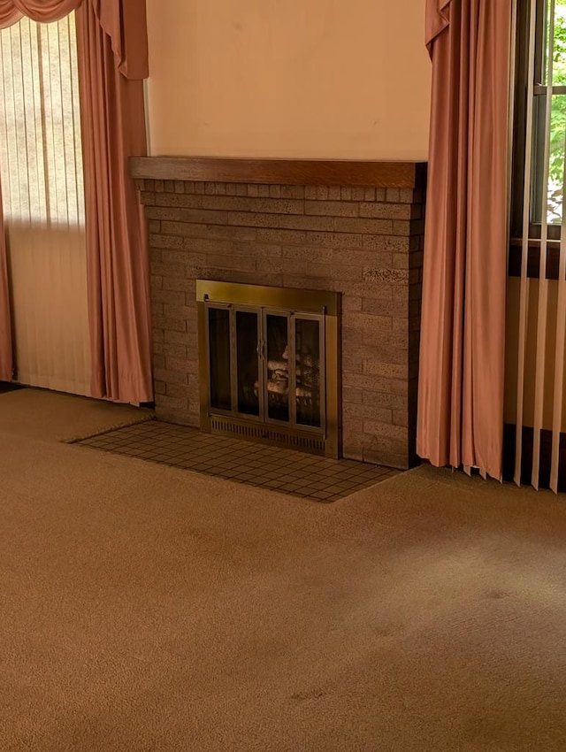 unfurnished living room with carpet flooring and a fireplace