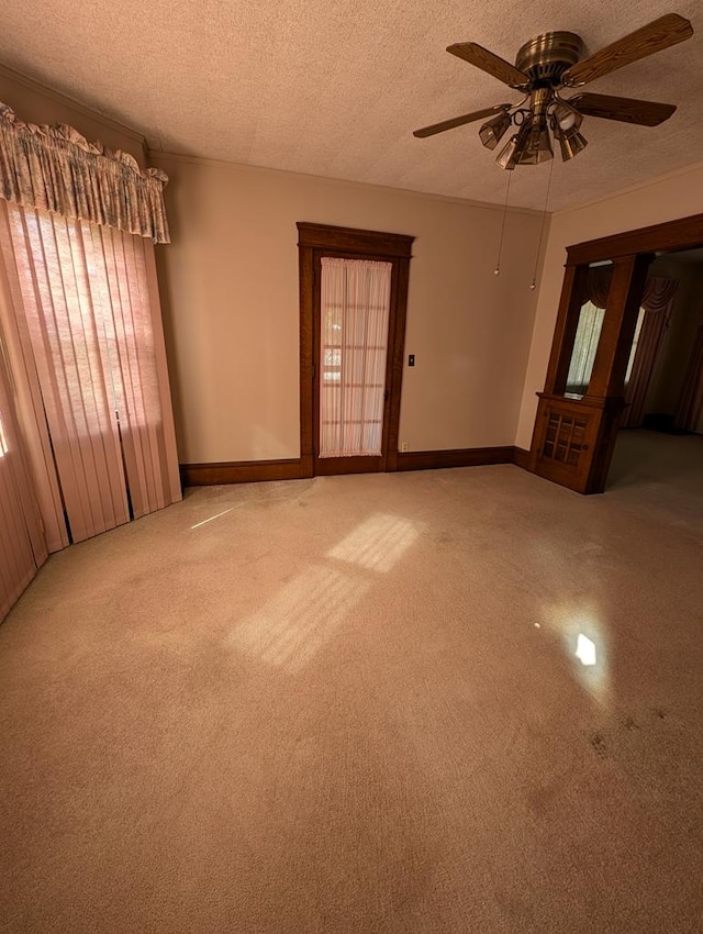 carpeted spare room featuring ceiling fan and a textured ceiling