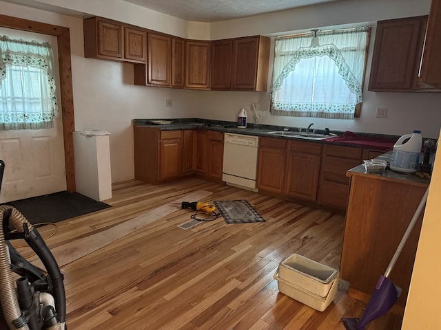 325 E Mansfield St, Bucyrus, OH 44820 - kitchen featuring white dishwasher, dark countertops, brown cabinetry, and light wood-style floors