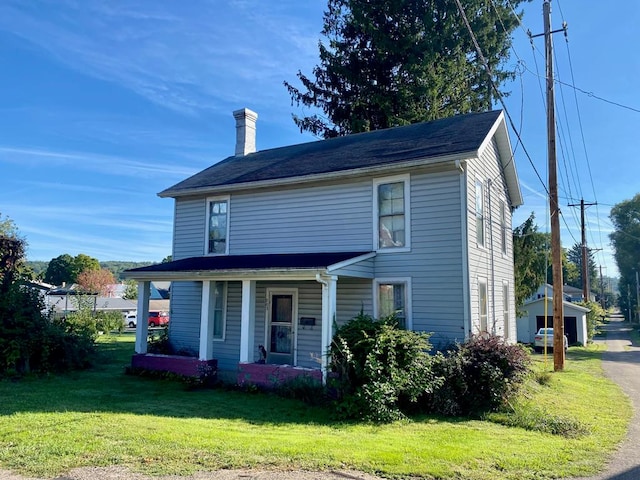 view of front of home featuring an outbuilding, a front lawn, a porch, and a garage