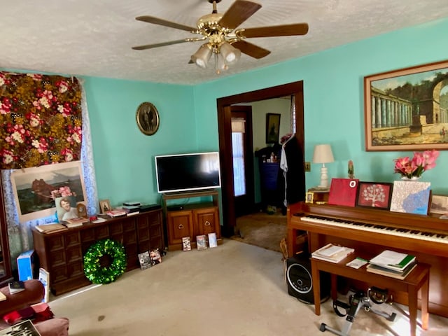 misc room featuring ceiling fan, a textured ceiling, and light carpet