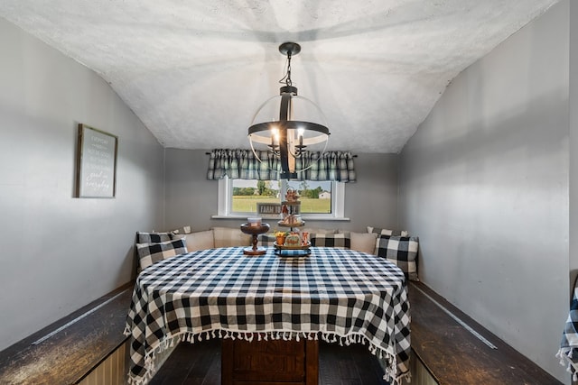 dining space featuring hardwood / wood-style floors, lofted ceiling, and a textured ceiling