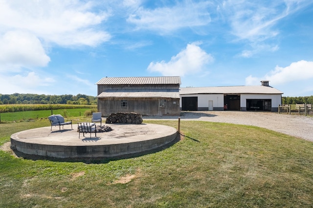 rear view of house featuring a yard, an outbuilding, and a rural view