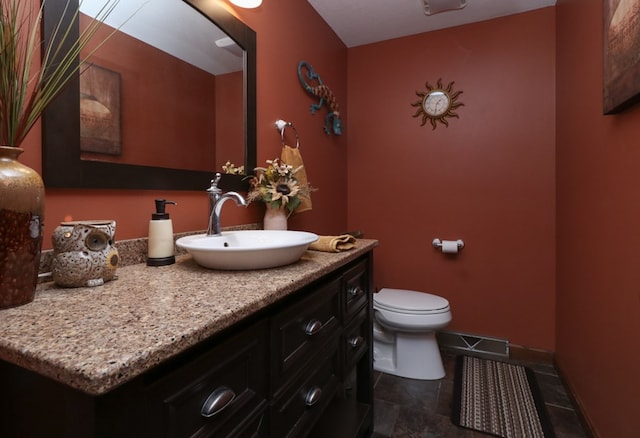 bathroom with baseboards, visible vents, toilet, and vanity