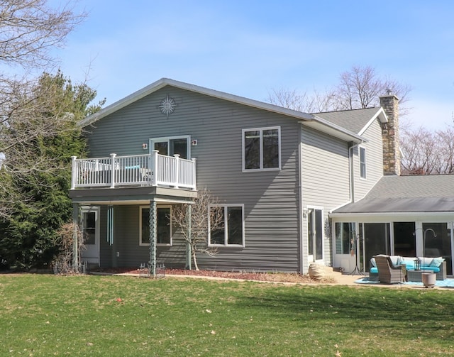 back of house featuring outdoor lounge area, a chimney, a lawn, and roof with shingles
