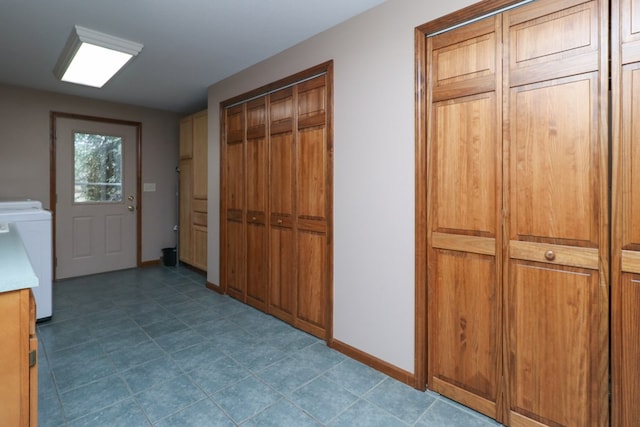 interior space featuring baseboards, cabinet space, and washer / dryer
