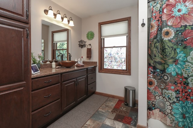 bathroom featuring a shower with curtain, vanity, baseboards, and a wealth of natural light