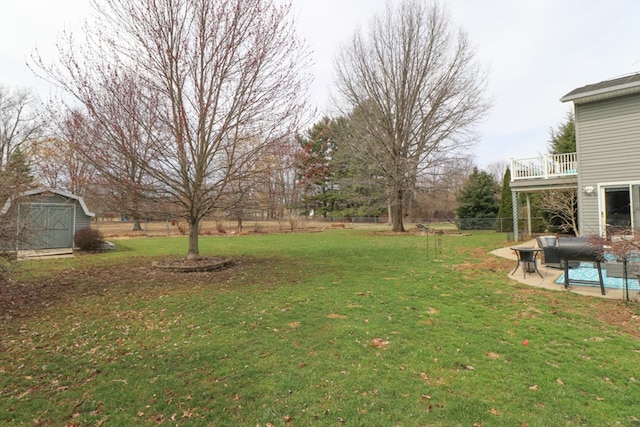 view of yard with fence, an outbuilding, a patio area, and a storage shed