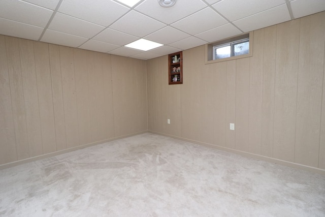 below grade area with carpet flooring and a paneled ceiling