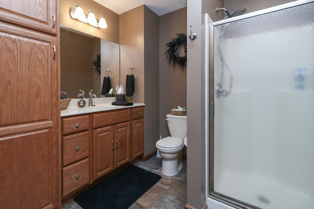 full bathroom featuring a stall shower, toilet, and vanity