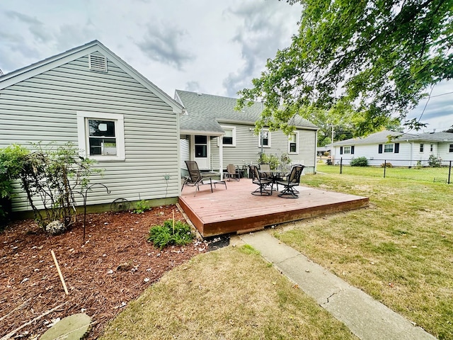 rear view of house featuring a lawn and a deck