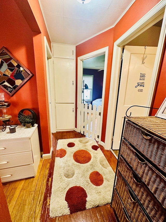 hall with hardwood / wood-style floors and ornamental molding