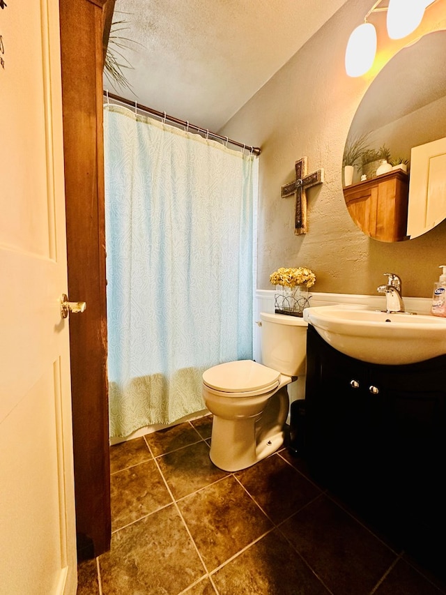 bathroom featuring a textured ceiling, vanity, and toilet