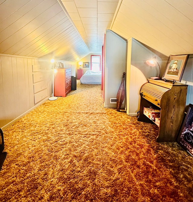 bedroom featuring carpet flooring, lofted ceiling, and wooden walls