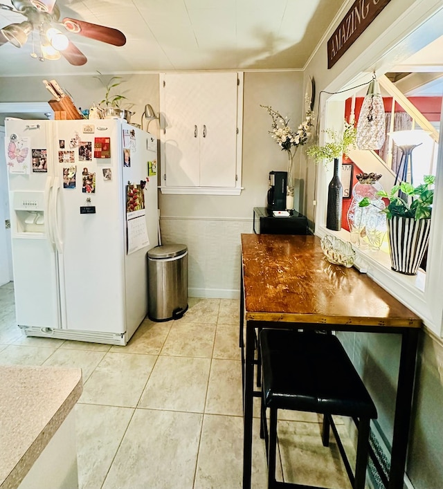 kitchen featuring ceiling fan, light tile patterned floors, and white refrigerator with ice dispenser