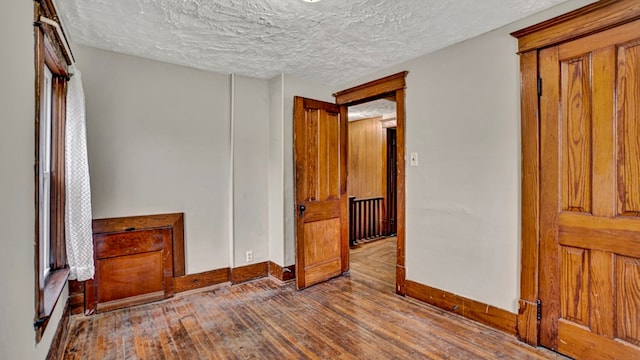 bedroom with a textured ceiling and light hardwood / wood-style flooring