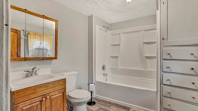 full bathroom with bathtub / shower combination, vanity, a textured ceiling, wood-type flooring, and toilet