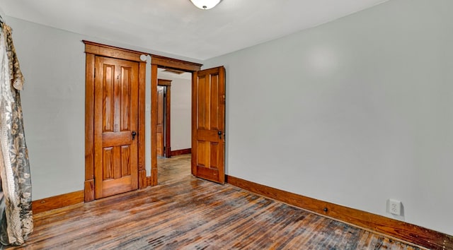 unfurnished room with wood-type flooring