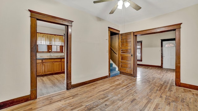 unfurnished room featuring light wood-type flooring, ceiling fan, and sink