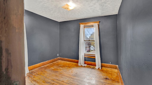 spare room with hardwood / wood-style floors and a textured ceiling