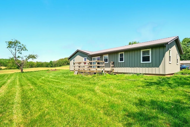 560 Harlan Rd, Mansfield, OH 44843 - rear view of property featuring board and batten siding, a deck, a yard, and metal roof