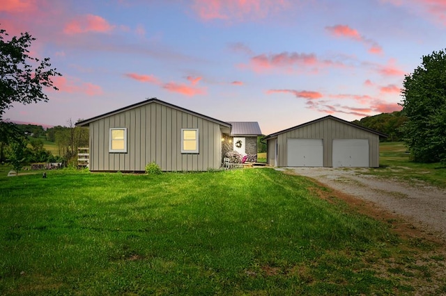 560 Harlan Rd, Mansfield, OH 44843 - view of front facade with a garage, an outbuilding, a yard, and board and batten siding