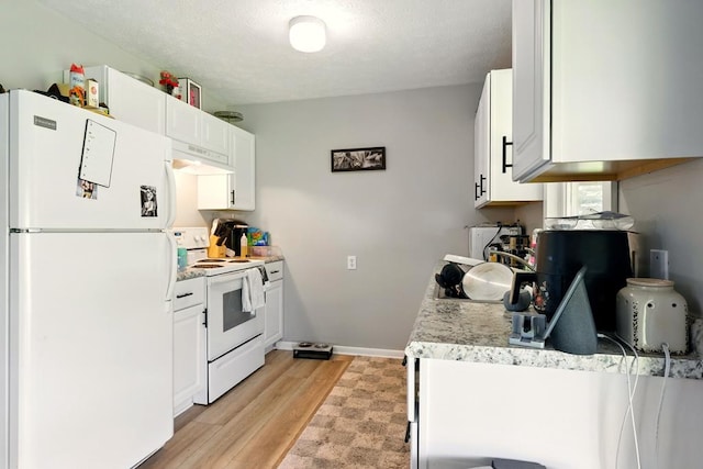 560 Harlan Rd, Mansfield, OH 44843 - kitchen featuring white appliances, light wood-style floors, light countertops, under cabinet range hood, and white cabinetry