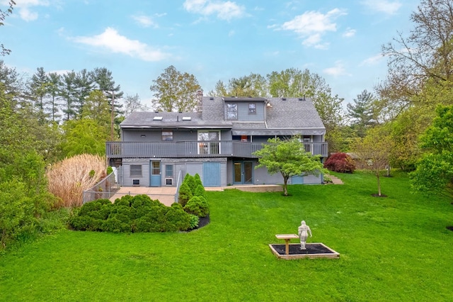 rear view of house with a lawn, a wooden deck, and a patio area
