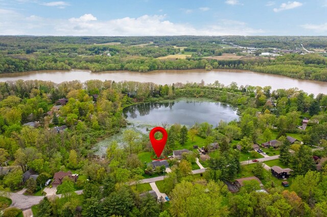 view of property location featuring a large body of water and a heavily wooded area