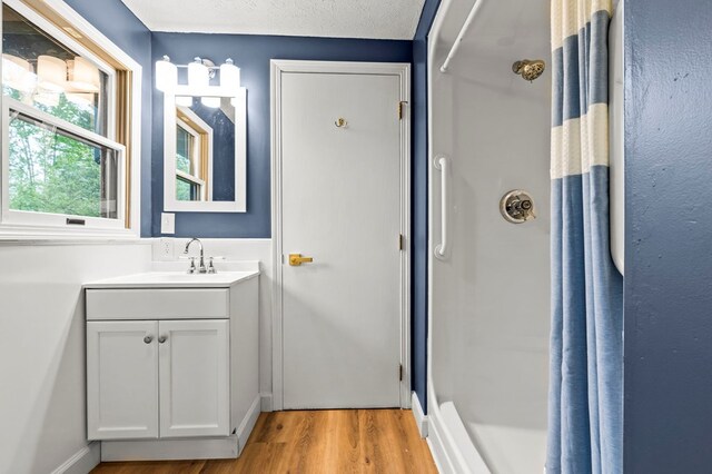 full bathroom featuring wood finished floors, a shower with shower curtain, and vanity
