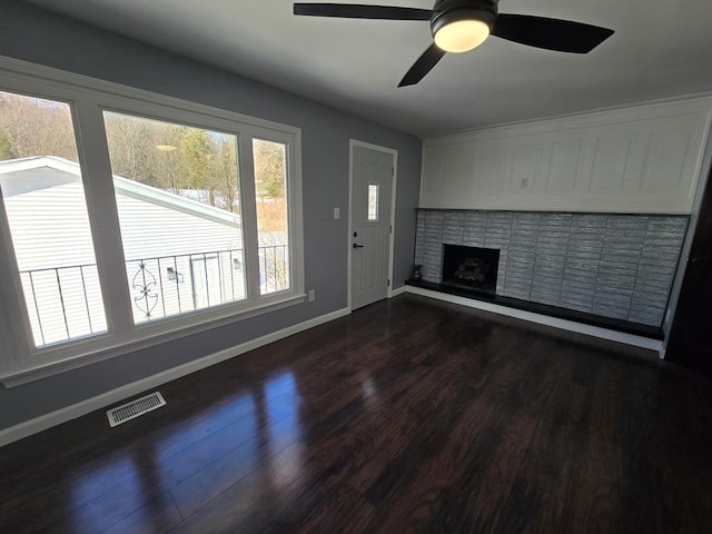 unfurnished living room with ceiling fan, a fireplace, and dark hardwood / wood-style flooring