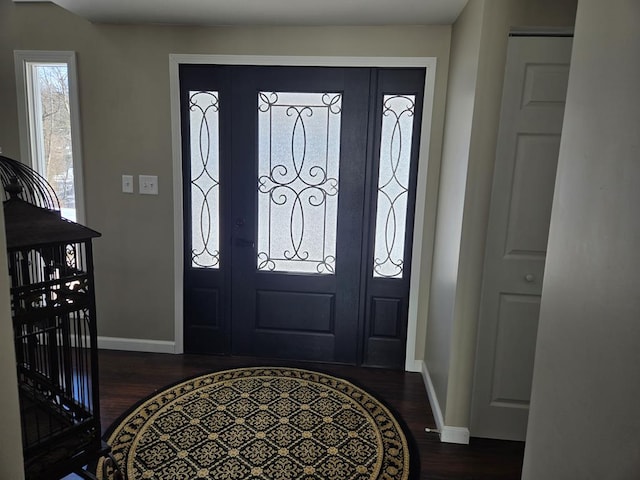 foyer entrance featuring baseboards and dark wood finished floors