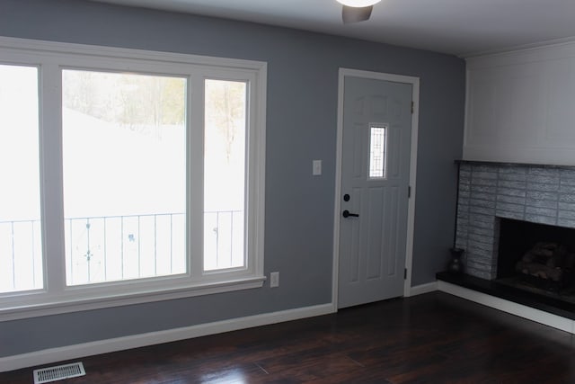 foyer entrance featuring dark hardwood / wood-style flooring, a fireplace, and ceiling fan