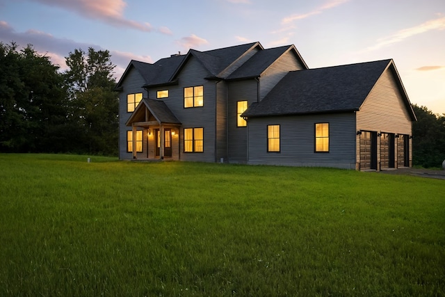 1360 Lexington Ontario Rd, Mansfield, OH 44904 - back of property at dusk featuring a lawn, a shingled roof, and an attached garage