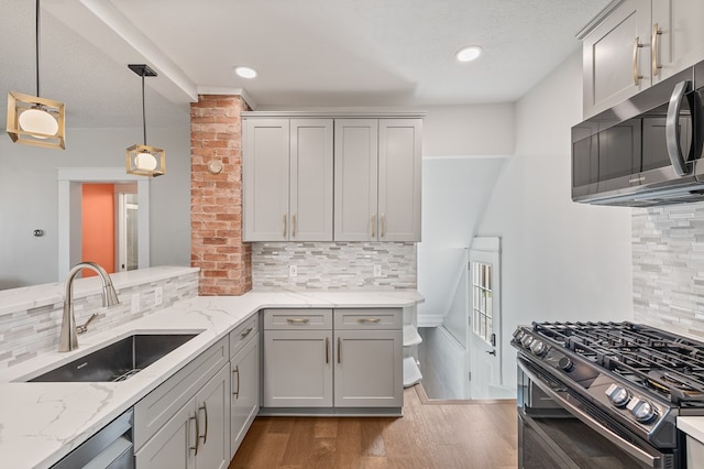 519 Park Ave, Galion, OH 44833 - kitchen with appliances with stainless steel finishes, dark wood-type flooring, backsplash, light stone countertops, and hanging light fixtures