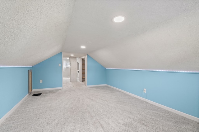 519 Park Ave, Galion, OH 44833 - additional living space with a textured ceiling, carpet, and vaulted ceiling