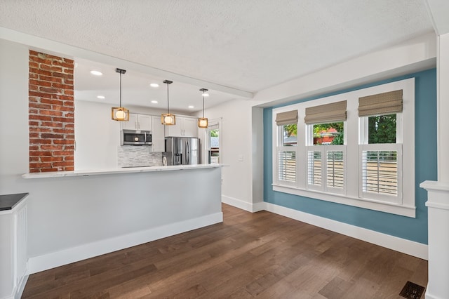 519 Park Ave, Galion, OH 44833 - kitchen featuring stainless steel appliances, decorative backsplash, dark wood finished floors, light countertops, and a textured ceiling