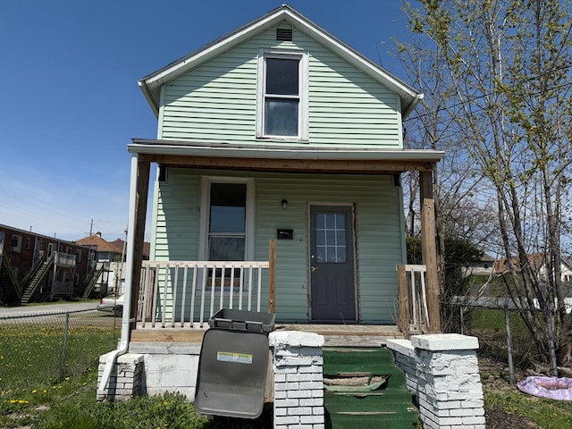shotgun-style home with fence and a porch