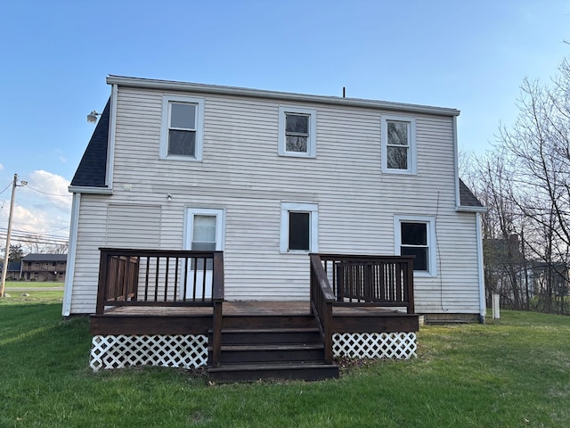 rear view of property featuring a yard, roof with shingles, and a deck