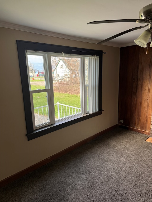 carpeted spare room with ornamental molding, baseboards, and ceiling fan