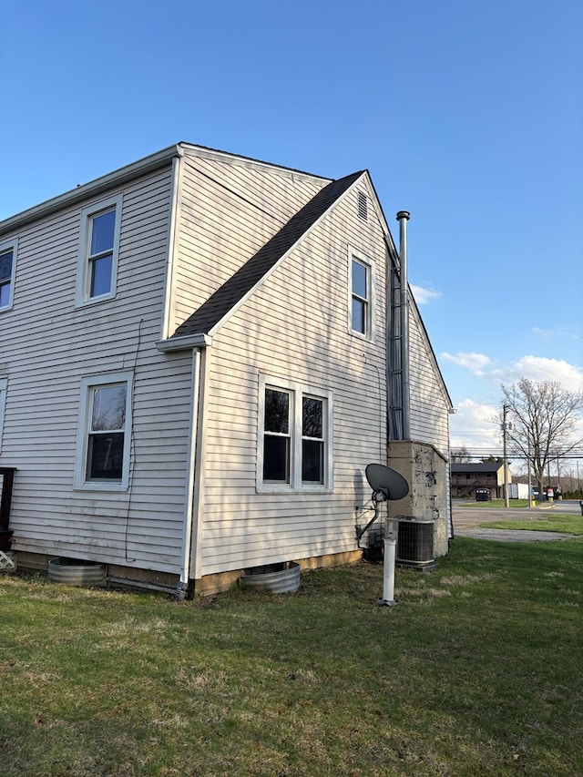 view of property exterior with a yard and central AC