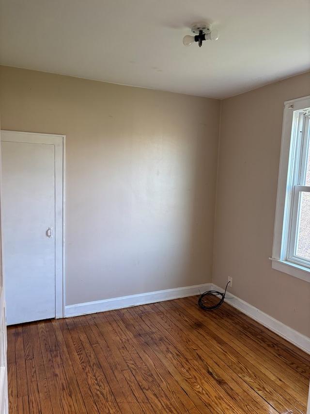 unfurnished room with baseboards and wood finished floors
