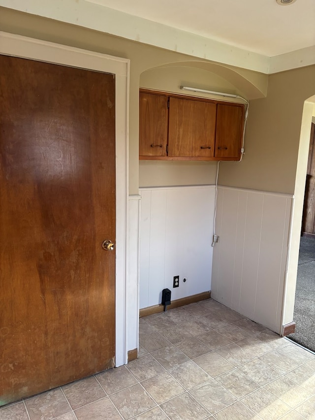 washroom featuring wainscoting and arched walkways