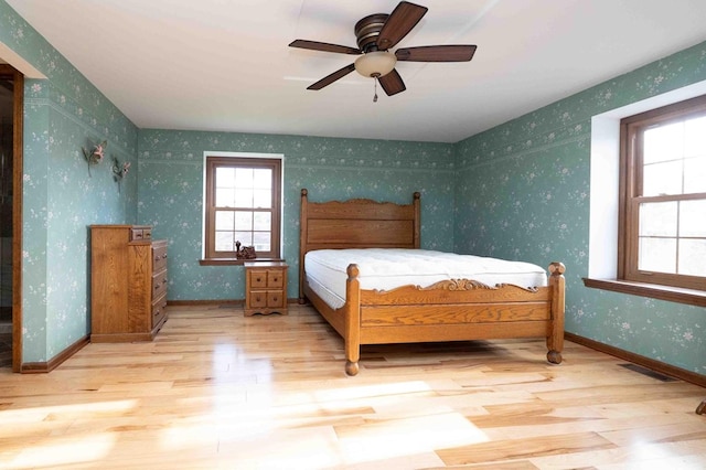 452 Pleasant Ln, Bucyrus, OH 44820 - bedroom featuring visible vents, baseboards, wallpapered walls, wood finished floors, and ceiling fan