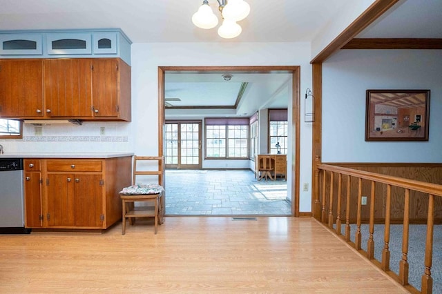 452 Pleasant Ln, Bucyrus, OH 44820 - kitchen with brown cabinets, an inviting chandelier, light countertops, stainless steel dishwasher, and light wood-type flooring