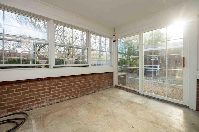 452 Pleasant Ln, Bucyrus, OH 44820 - unfurnished sunroom featuring concrete floors, a healthy amount of sunlight, crown molding, and brick wall