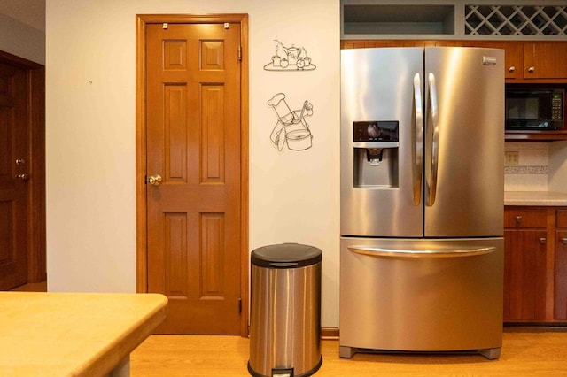 452 Pleasant Ln, Bucyrus, OH 44820 - kitchen with stainless steel refrigerator with ice dispenser, black microwave, light countertops, and light wood-style floors