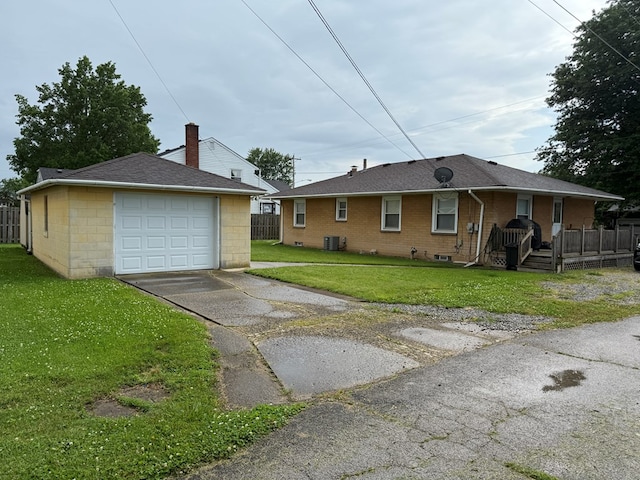 1022 S E E, Bucyrus, OH 44820 - view of front of house with asphalt driveway, a detached garage, a front lawn, and brick siding